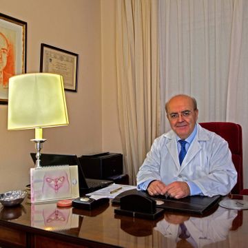 Clínica Ginecológica Dr. Francisco Valdivieso doctor en consultorio con cuadros